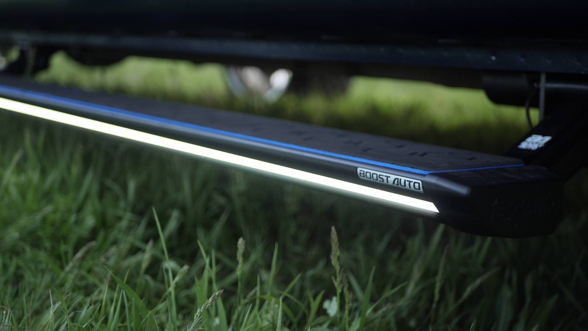 Close up of a deployed Boost Auto Lumastep M2 running board with a blue hex step pad
